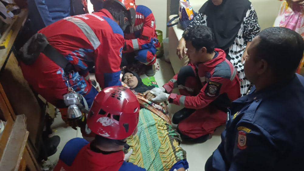 Tim Damkar Makassar evakuasi seorang ibu yang menderita stroke, Selasa (1/4/2025). Dok. IDN Times/Istimewa