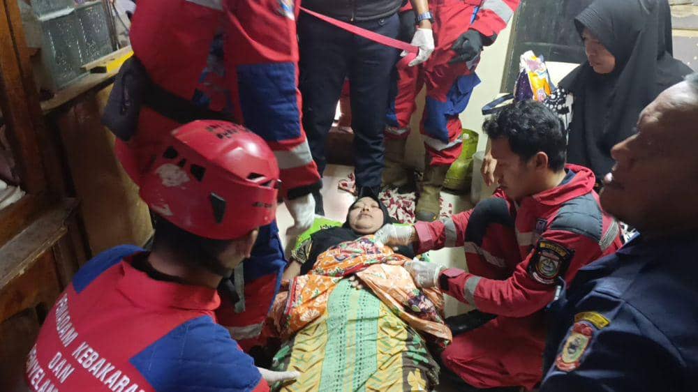 Tim Damkar Makassar evakuasi seorang ibu yang menderita stroke, Selasa (1/4/2025). Dok. IDN Times/Istimewa
