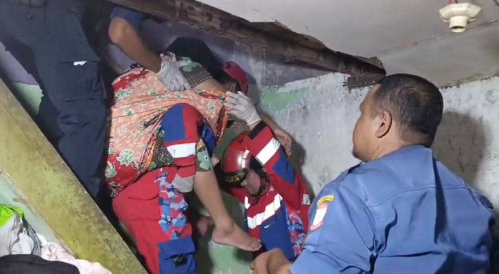 Tim Damkar Makassar evakuasi seorang ibu yang menderita stroke, Selasa (1/4/2025). Dok. IDN Times/Istimewa