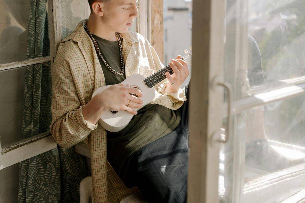 man with ukulele (Sumber:pexels/cottonbro)