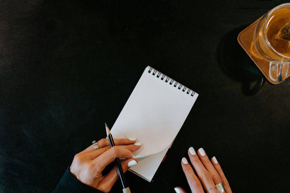 ilustrasi seseorang membawa catatan saat rapat (unsplash.com/Kelly Sikkema)