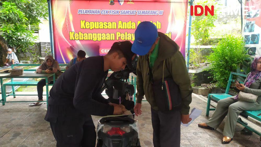 Seorang petugas cek fisik melayani wajib pajak di Samsat Hanoman Semarang. (IDN Times/Fariz Fardianto)