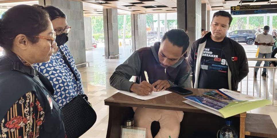 Seorang PMI menandatangani dokumen kedatangan saat tiba di NTT. (Dok BP3MI NTT)