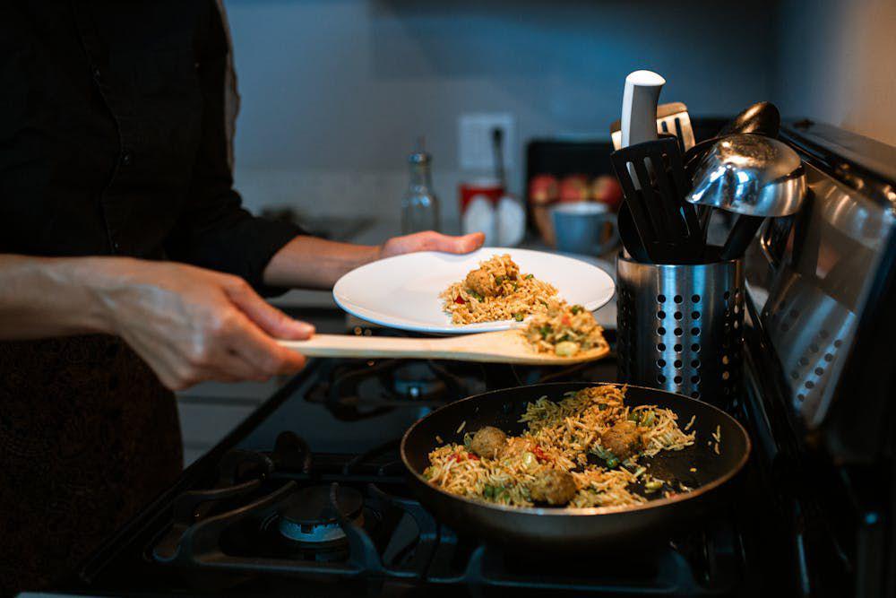 ilustrasi wanita membuat nasi goreng dari lauk sisa lebaran (pexels.com/RDNE Stock project)