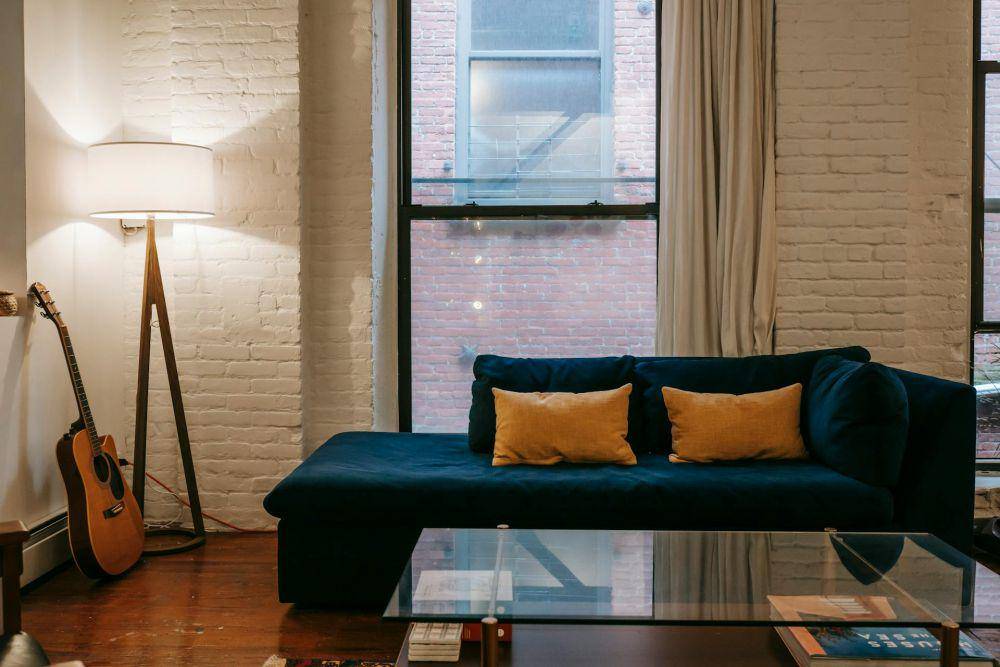 ilustrasi sofa biru tua dengan bantal warna mustard (pexels.com/Charlotte May)