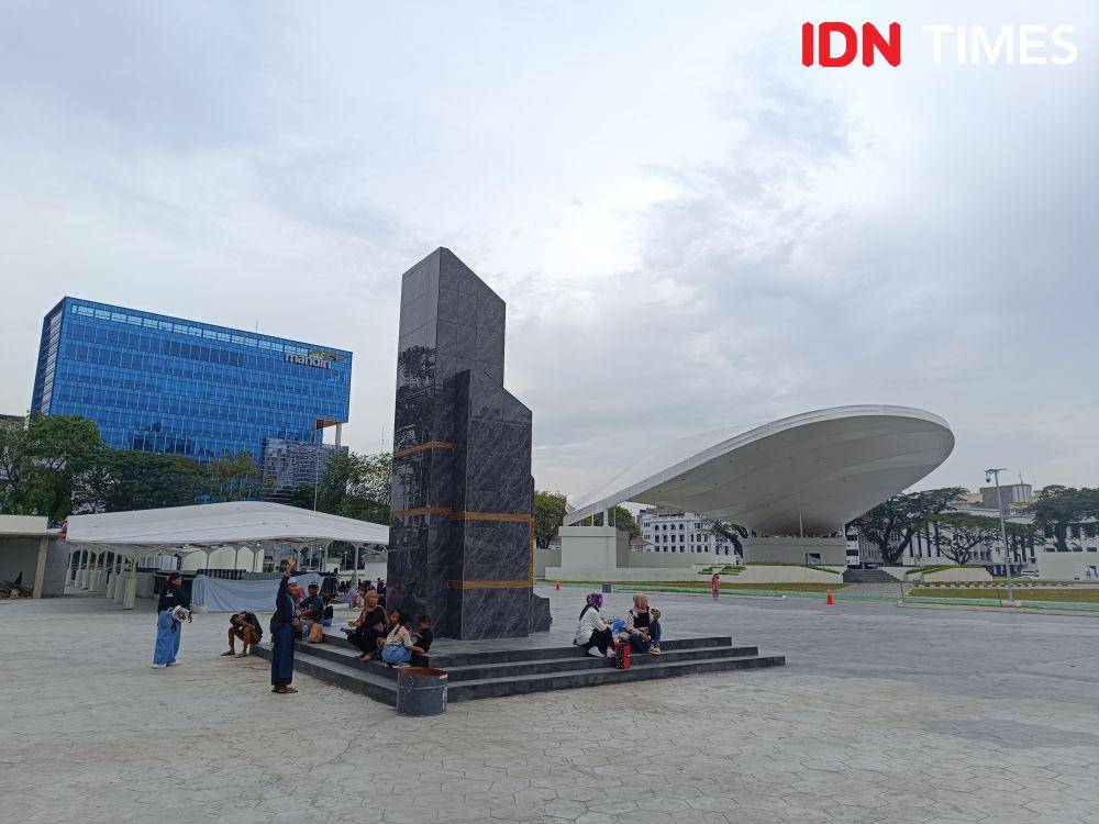 Warga Medan duduk santai di monumen yang berlokasi di Lapangan Merdeka Medan usai direvitalisasi (dok.Gidion Dwiputra Lumbantoruan)