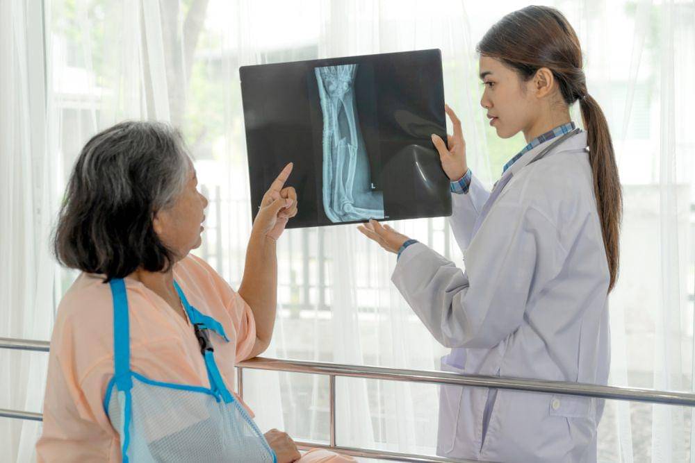 Dokter menunjukkan foto X-ray patah tulang pada pasien.