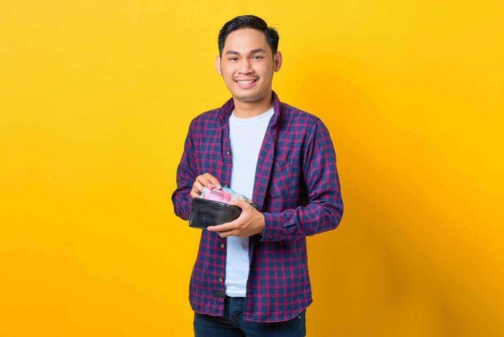 ilustrasi orang mengeluarkan uang dari dompet (pexels.com/Sewupari Studio)