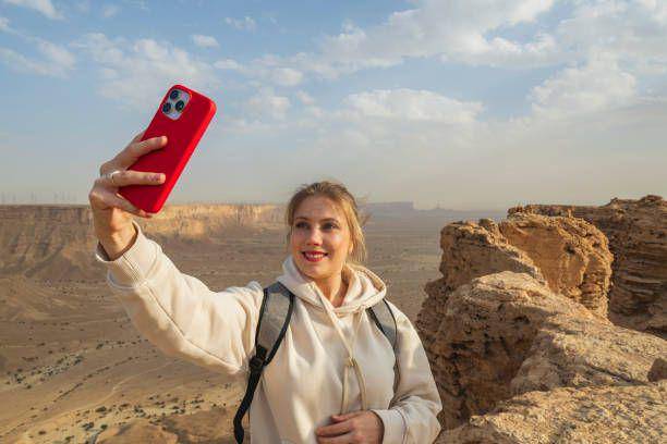 ilustrasi pendaki selfie di tepi tebing curam (iStock/johnnyGreigu)