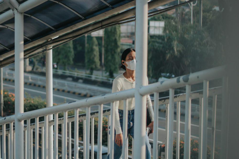 Ilustrasi perempuan di halte Transjakarta (unsplash.com/Andri Aprianto)