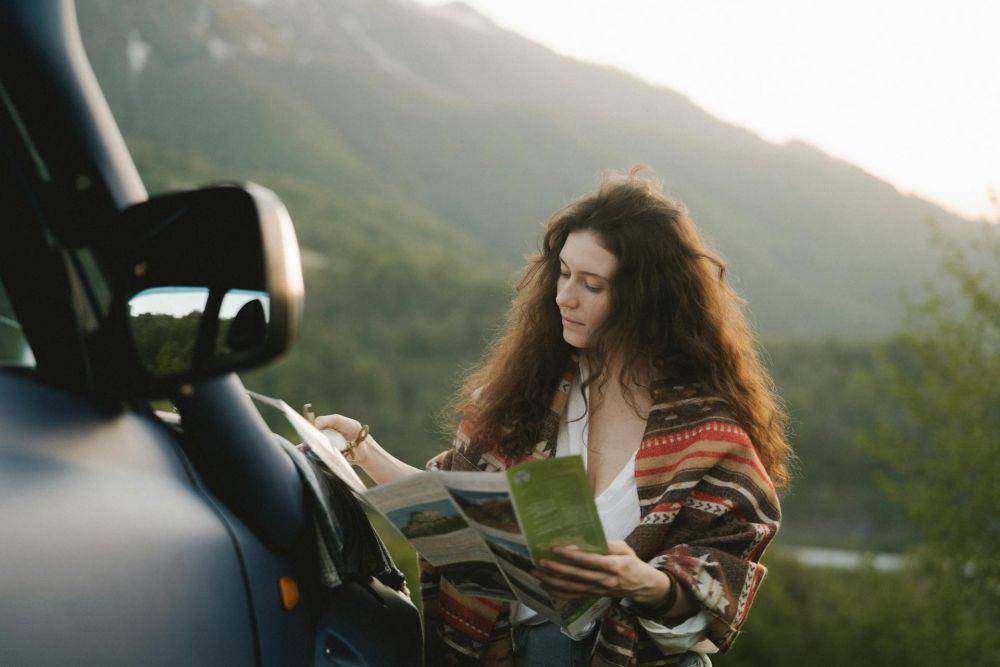 Ilustrasi perempuan membaca brosur open trip (pexels.com/Anastasia Shuraeva)