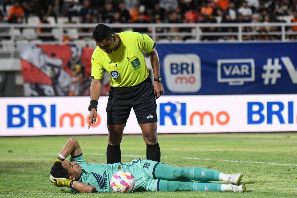 Wasit Sance Lawita (kanan) memastikan kondisi dari penjaga gawang PSM Makassar M. Reza Arya Pratama (kiri) saat melawan Borneo FC Samarinda dalam pertandingan Liga 1 2024/2025 di Stadion Segiri, Samarinda, Kalimantan Timur, Jumat (18/4/2025). ANTARA FOTO/M Risyal Hidayat/foc.