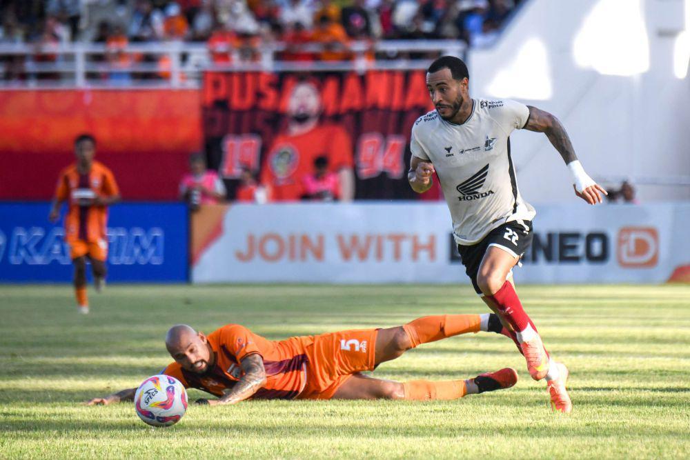 Pesepak bola Borneo FC Samarinda Gabriel Furtado (kiri) terjatuh saat berebut bola dengan pesepak bola PSM Makassar Victor Luiz (kanan) saat pertandingan Liga 1 2024/2025 di Stadion Segiri, Samarinda, Kalimantan Timur, Jumat (18/4/2025). ANTARA FOTO/M Risyal Hidayat/foc.