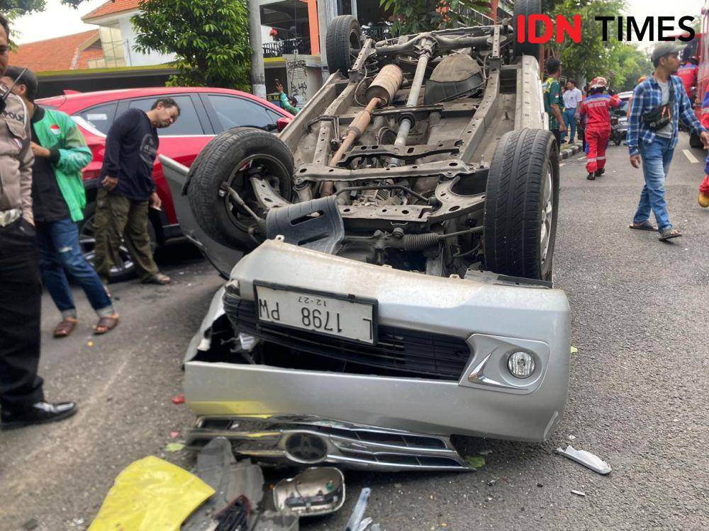Mobil Avanza silver mengalami kecelakaan hingga terbalik di depan SMAN 9 Surabaya tempatnya Jalan Kusuma Bangsa, Selasa (22/4/2025). (IDN Times/Khusnul Hasana).