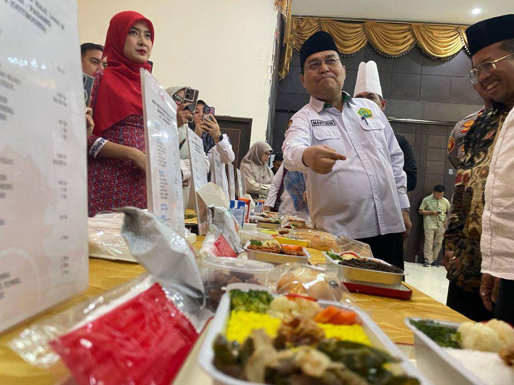 Kepala Kantor Kemenag Sumbar, Mahyudin melakukan tes meal makanan untuk CJH Sumbar di pesawat (Foto: IDN Times/Halbert Caniago)