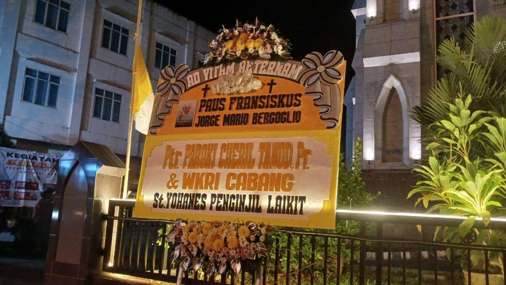 Bendera setengah tiang dan karangan bunga dukacita meninggalnya Paus Fransiskus di depan Gereja Katedral Manado, Jalan Sam Ratulangi, Manado, Sulawesi Utara, Selasa (22/4/2025). IDNTimes/Savi