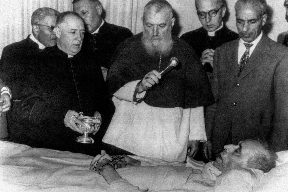 Kardinal Eugéne Tisserant memercikkan air suci ke tubuh Paus Pius XII saat ia berbaring di ranjang kematiannya di Castel Gandolfo, di wilayah Lazio, Italia. (commons.wikimedia.org/Donrdg54)