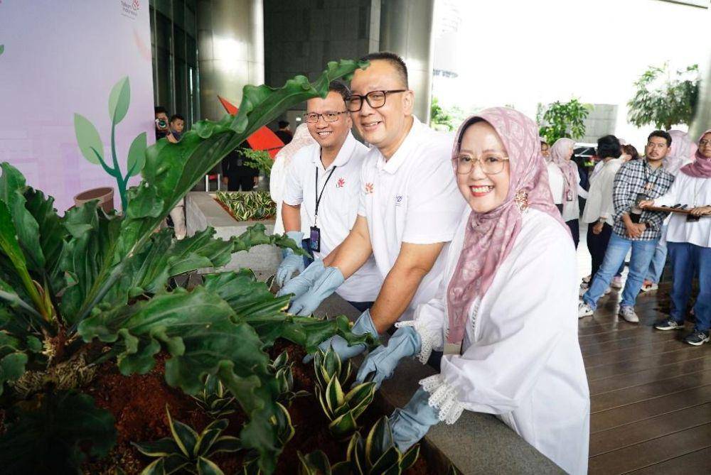 VP Sustainability Telkom Gunawan Wasisto Ciptaning Andri (kiri), SVP Group Sustainability and Corporate Communication Telkom Ahmad Reza (tengah), dan Ketua Srikandi TelkomGroup Reni Yustiani (kanan) pada kegiatan penanaman pohon sansevieria di lingkungan kantor dalam program “Jejak Hijau Srikandi” di Telkom Landmark Tower, Jakarta, pada Selasa (22/4) (dok. Telkom)