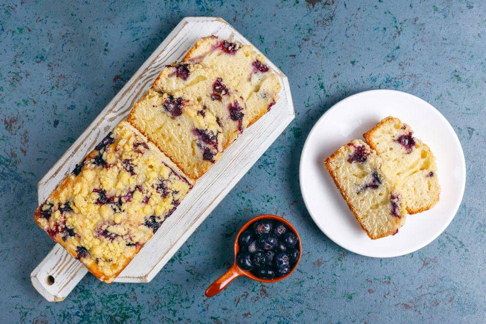Ilustrasi blueberry crumble cake dengan lapisan remah renyah dan blueberry, sebagai sajian makanan penutup.