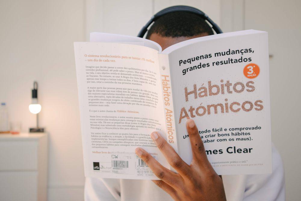 Ilustrasi pria membaca buku Atomic Habits (unsplash.com/Nubelson Fernandes)