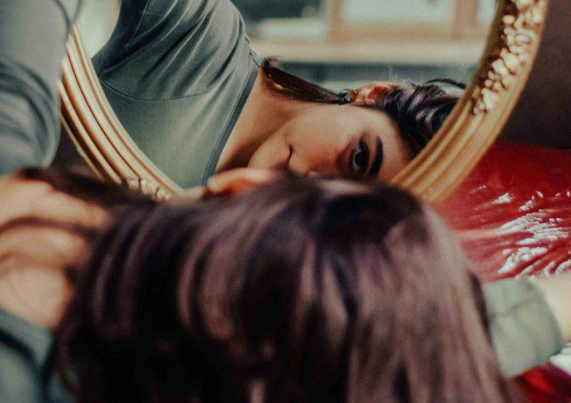 gambar seorang perempuan memegang cermin (unsplash.com/Negar Nikkhah)