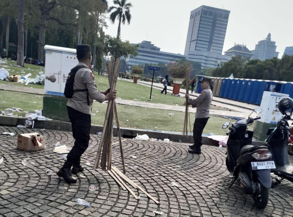 Personel Polri Bersih-bersih Kawasan Monas Usai May Day Fiesta