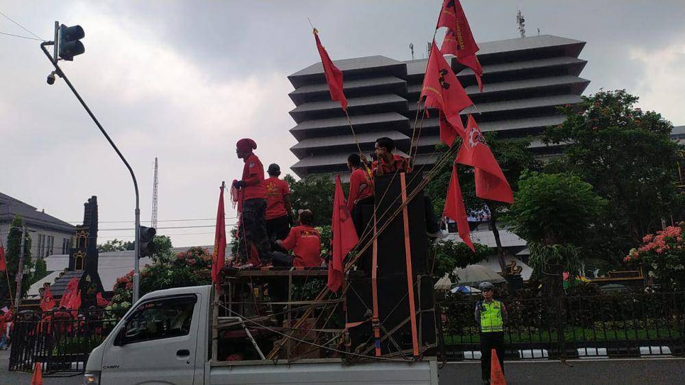 Konfederasi Kongres Aliansi Serikat Buruh Indonesia (KASBI) menyita perhatian warga Semarang dengan membawa simbol-simbol berwarna merah merona. (IDN Times/Fariz Fardianto)