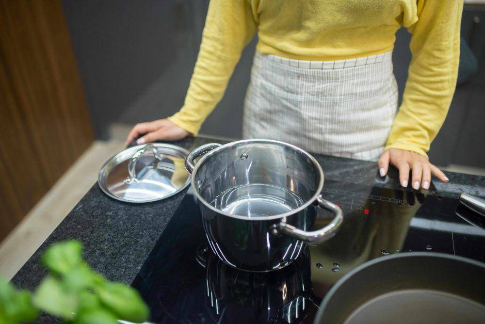 ilustrasi orang memasak menggunakan kompor listrik (pexels.com/Kampus Production)