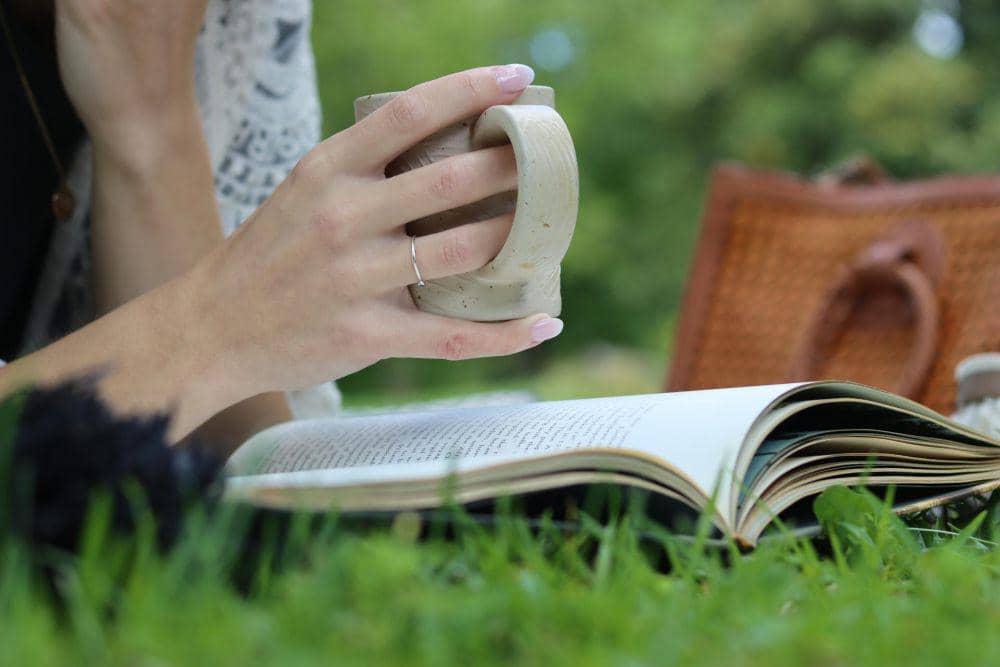ilustrasi seseorang membaca buku dan minum kopi (pexels.com/Daniel & Hannah Snipes)