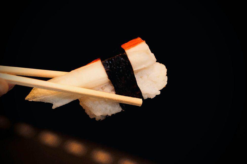 ilustrasi makan sushi dengan sumpit (unsplash.com/Andrey Câmara)
