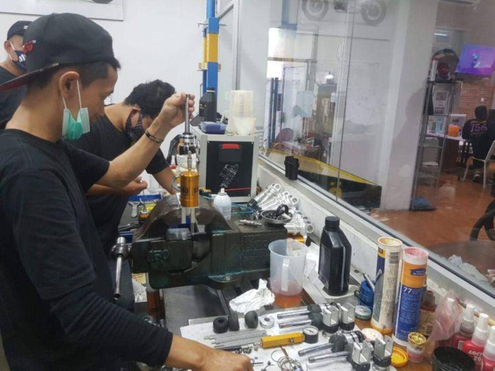 Ilustrasi mekanik yang sedang melakukan perawatan pada shockbreaker Öhlins (ohlinsindonesia.com)