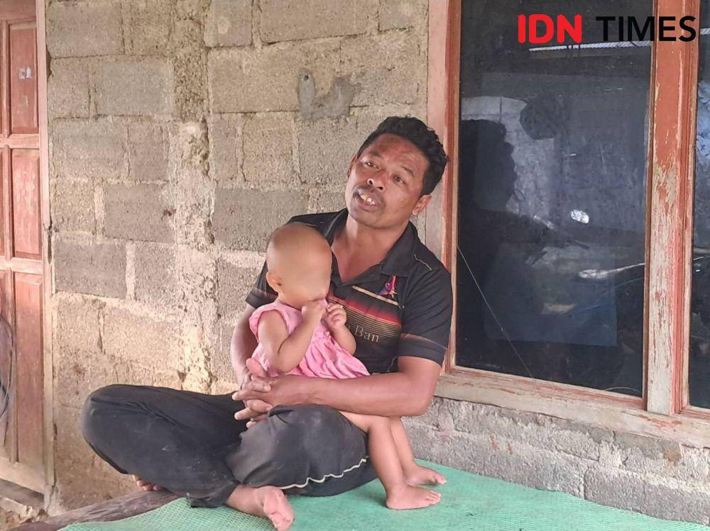 Kelian Desa Adat Manikaji, Nengah Sudana sambil memangku anak kelimanya yang berusia 1 tahun. (IDN Times/Irma Yudistirani)