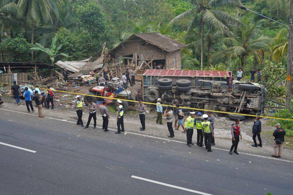 Polisi berjaga di lokasi kecelakaan truk tronton bermuatan pasir tabrak mobil angkutan umum di jalan turunan Magelang-Purworejo Desa Kalijambe, Bener, Purworejo, Jawa Tengah, Rabu (7/5/2025). (ANTARA FOTO/Anis Efizudin)