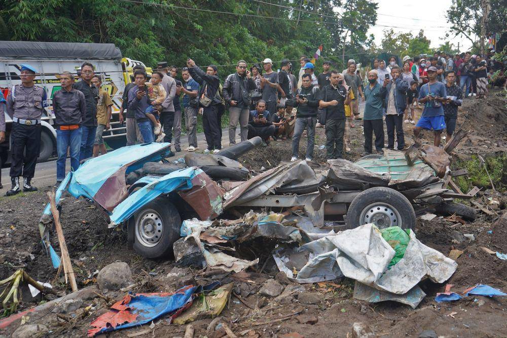 Warga melihat mobil angkutan yang ringsek tertabrak truk tronton bermuatan pasir di jalan turunan Magelang-Purworejo Desa Kalijambe, Bener, Purworejo, Jawa Tengah, Rabu (7/5/2025). (ANTARA FOTO/Anis Efizudin)