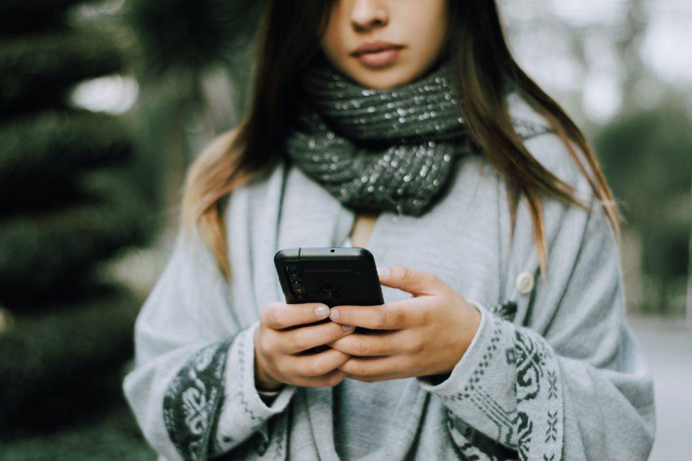 Ilustrasi wanita menggunakan ponsel (unsplash.com/Miguelangel Perez)