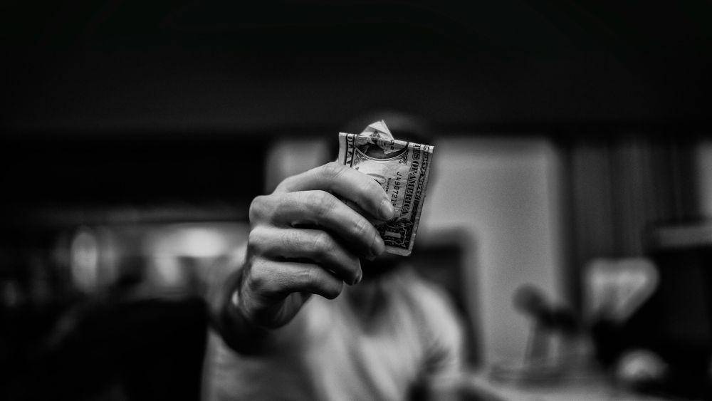 Ilustrasi seseorang memegang uang (unsplash.com/lucas Favre)