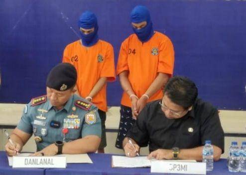 Dua tersangka TPPO menggunakan baju tahanan berwarna oranye (IDN Times/ dok BP3MI Riau)