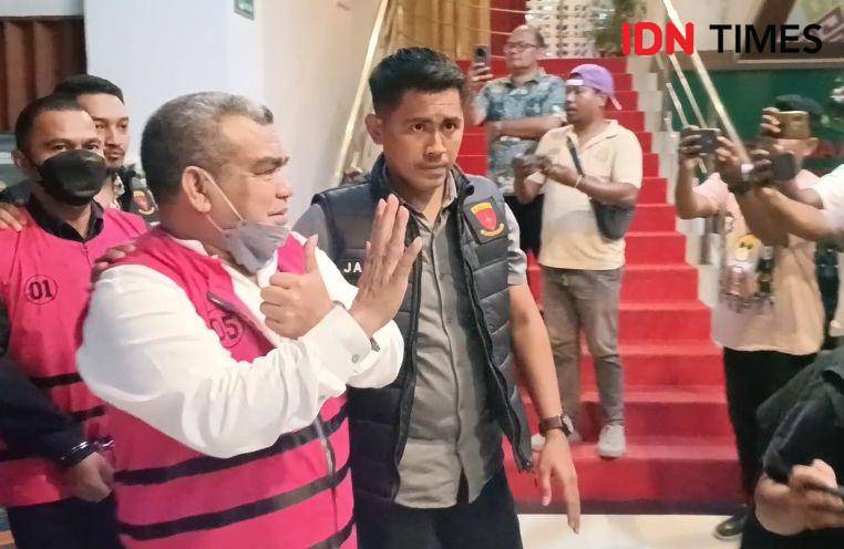 Dirut Jamkrida NTT melambaikan tangan kepada wartawan saat ditahan Kejati NTT sebagai tersangka korupsi. (IDN Times/Putra F. D. Bali Mula)
