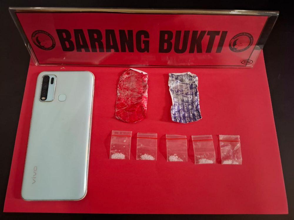 Barang bukti lima paket sabu, ponsel, dan alumunium foil yang digunakan untuk membungkus sabu diamankan kepolisian. (Dok. Humas Polres PPU)