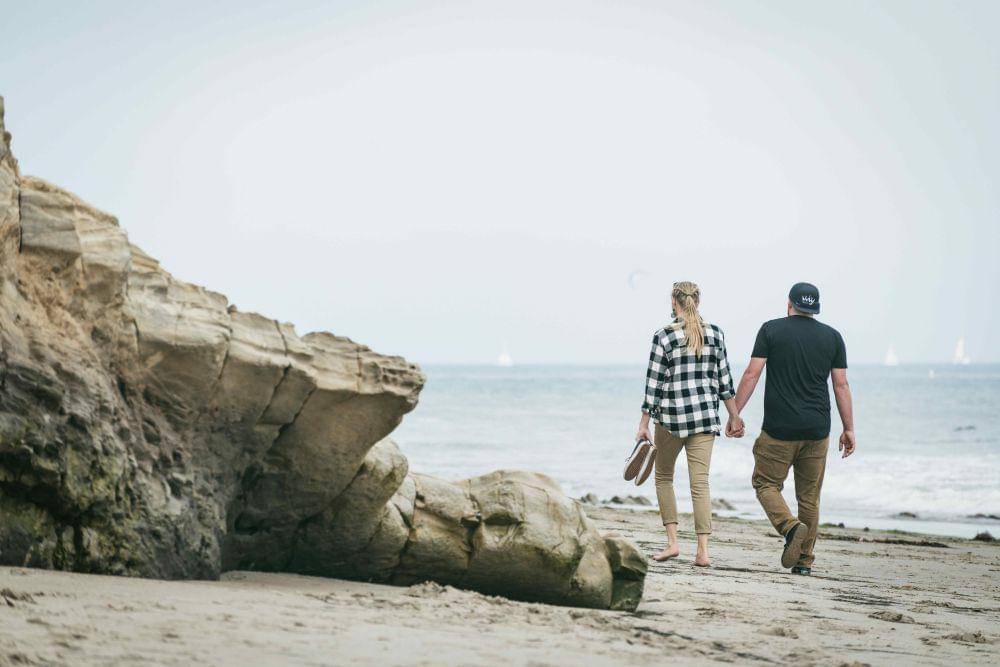 ilustrasi pasangan sedang berjalan di pinggir pantai (unsplash.com/Tim Mossholder)