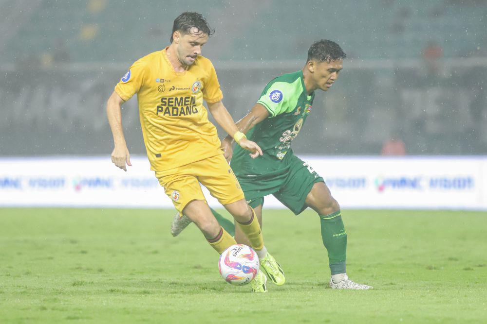 Pesepak bola Semen Padang Tin Martic (kiri) melewati adangan pesepak bola Persebaya Surabaya Arief Catur Pamungkas (kanan) pada pertandingan BRI Liga 1 di Stadion Gelora Bung Tomo, Surabaya, Jawa Timur, Minggu (11/5/2025). ANTARA FOTO/Rizal Hanafi/nym.