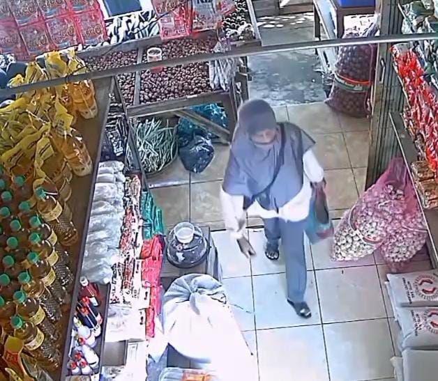 Tangkapan layar CCTV seorang perempuan berhijab curi beras dan tabung gas di pasar Paron Ngawi. IDN Times/ Riyanto.