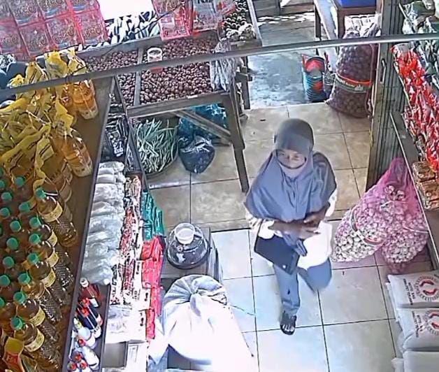 Tangkapan layar CCTV seorang perempuan berhijab curi beras dan tabung gas di pasar Paron Ngawi. IDN Times/ Riyanto.