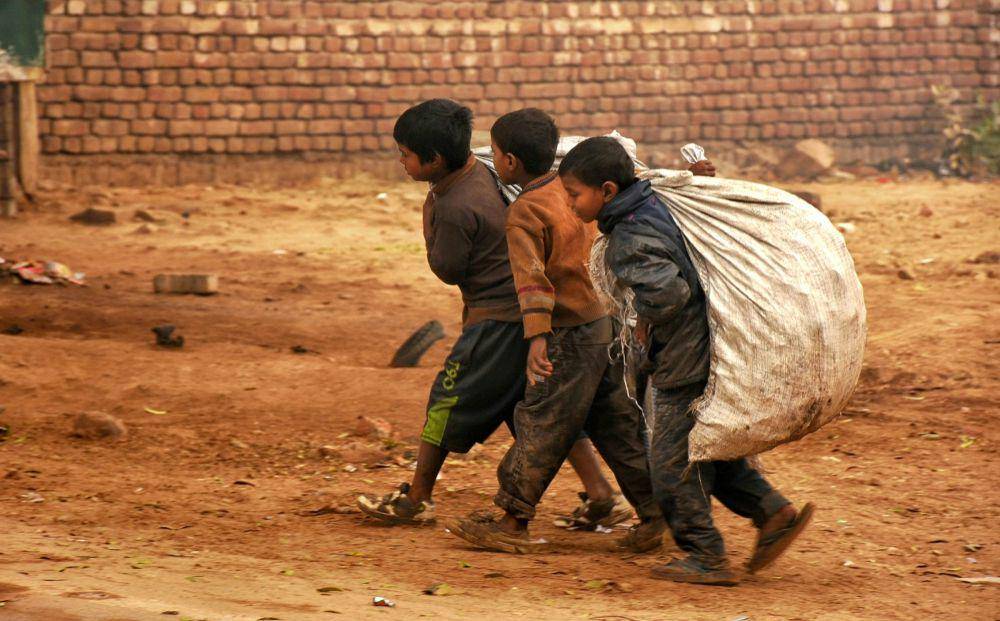 Ilustrasi tiga orang anak yang sedang membawa sekarung sampah (unsplash.com/Dulana Kodithuwakku)