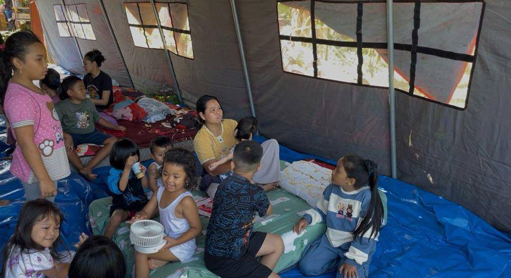 Desi bersama warga lainnya tidur di tenda pengungsian karena terdampak kebakaran pabrik karet (Foto: IDN Times/Halbert Caniago)
