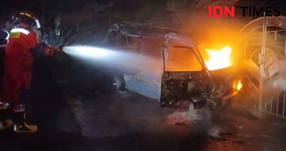 Sebuah angkutan kota (angkot) terbakar saat melaju dan menabrak pagar rumah warga di Jalan Telindung RT 15, Kelurahan Batu Ampar, Balikpapan Utara, Senin (19/5/2025). (IDN Times/Hilmansyah)