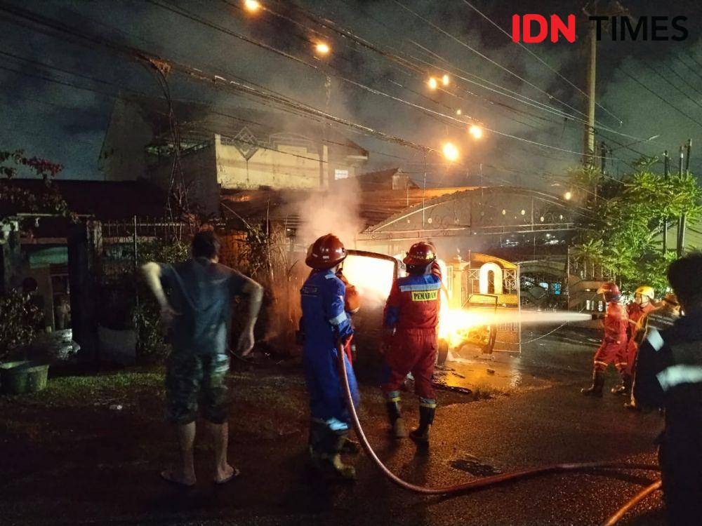 Sebuah angkutan kota (angkot) terbakar saat melaju dan menabrak pagar rumah warga di Jalan Telindung RT 15, Kelurahan Batu Ampar, Balikpapan Utara, Senin (19/5/2025). (IDN Times/Hilmansyah)