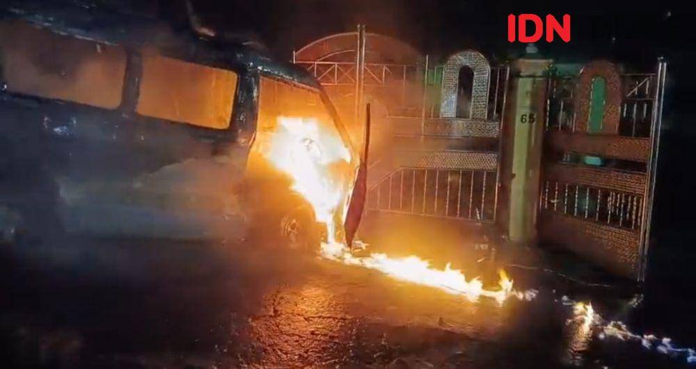 Sebuah angkutan kota (angkot) terbakar saat melaju dan menabrak pagar rumah warga di Jalan Telindung RT 15, Kelurahan Batu Ampar, Balikpapan Utara, Senin (19/5/2025). (IDN Times/Hilmansyah)