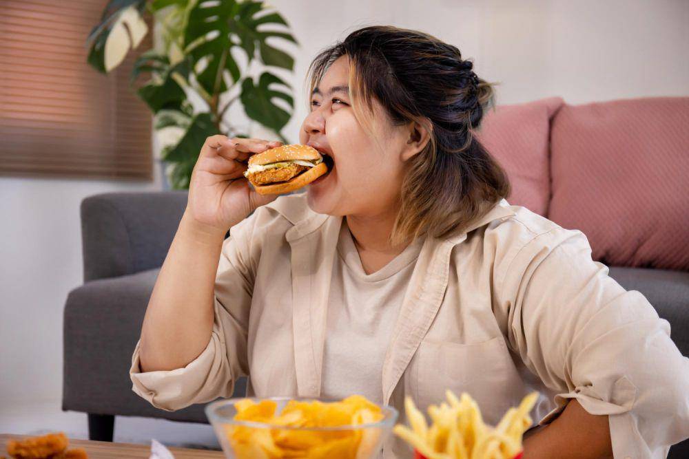 ilustrasi perempuan makan junk food (freepik.com/studioredcup)