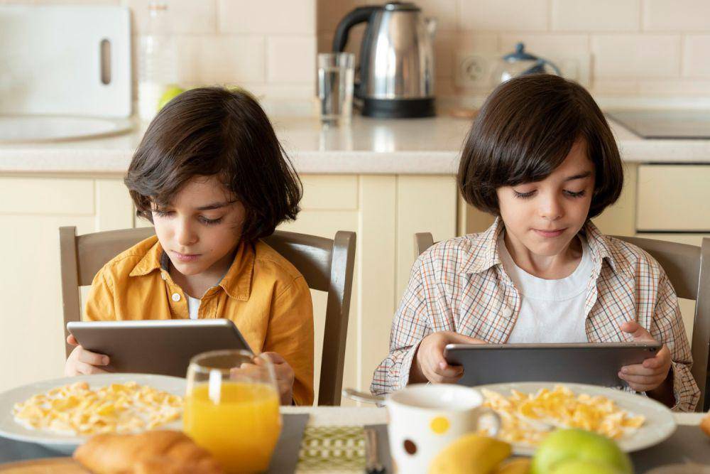Ilustrasi anak makan sambil memegang gedget (freepik.com/freepik)